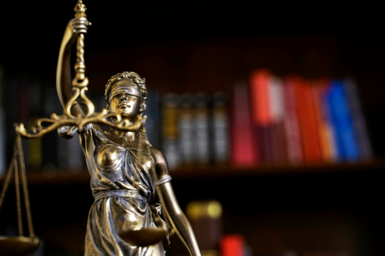 Foto Diosa de la Justicia con biblioteca de fondo