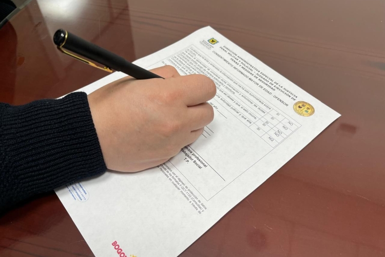 una persona firmando un documento